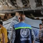 An UNRWA staff member and displaced Palestinians assess the damage inside a UN school converted into a shelter at al-Shati refugee camp, near Gaza City, Gaza Strip, on October 19, 2024.